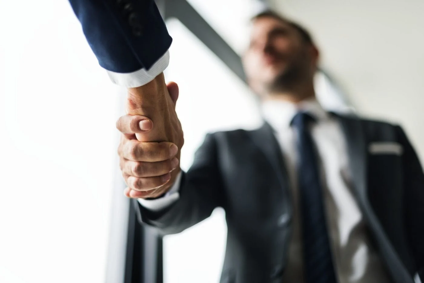 A firm handshake between two professionals in suits