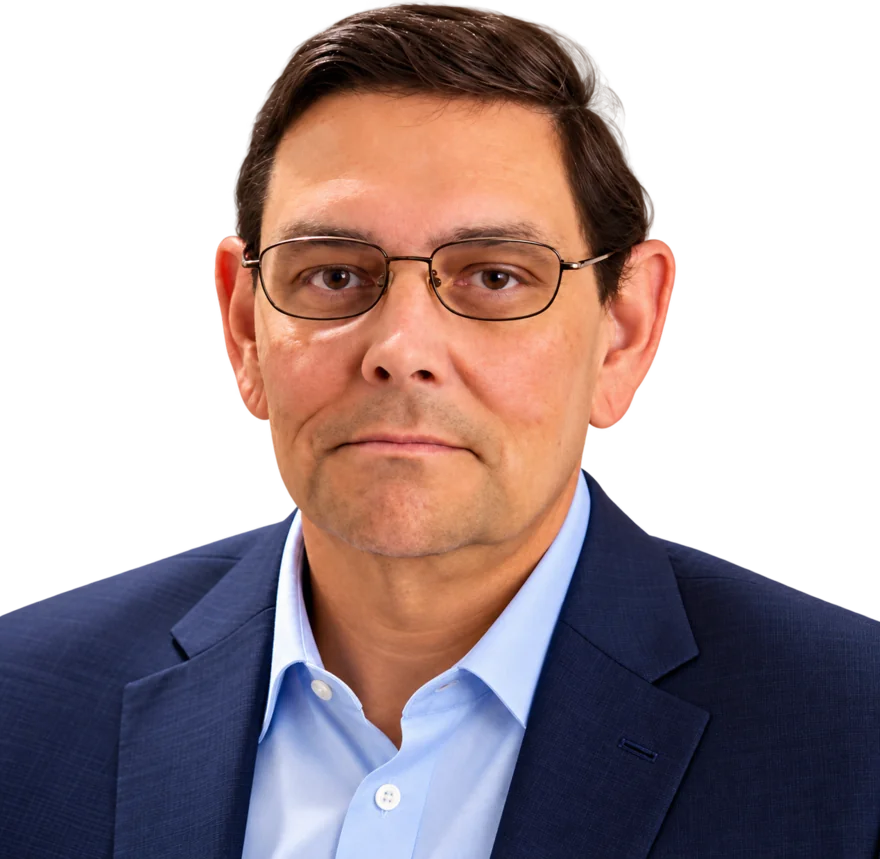 Portrait of John McCarty, insurance broker, wearing a navy suit, light blue shirt, and glasses